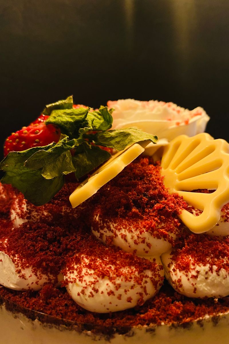 Red velvet cake with cream cheese frosting, strawberries and chocolate